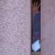 A man being held inside the Metropolitan Detention Center, which houses detained immigrants, responds to calls of encouragement from demonstrators on the street below on June 30, 2018 in Los Angeles, California.